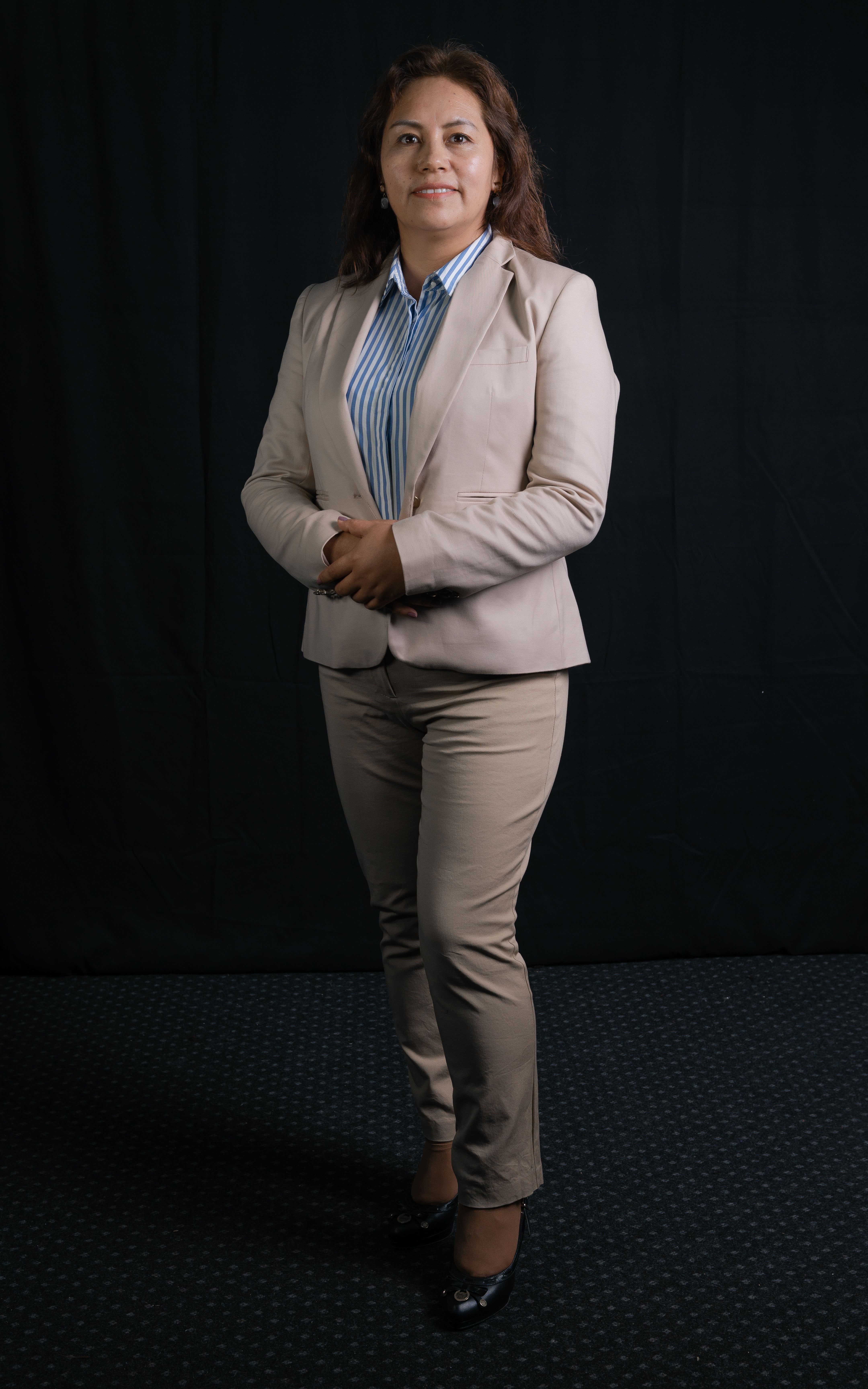 Studio portrait of an elegant businesswoman in beige suit, showcasing professional fashion style.