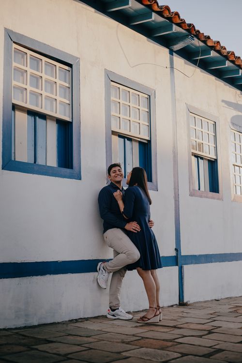 Free Joyful couple shares a loving moment by a blue and white wall outdoors. Stock Photo