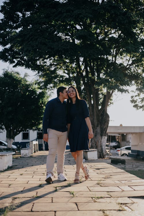 Young Couple Walking on the Sidewalk and Smiling 