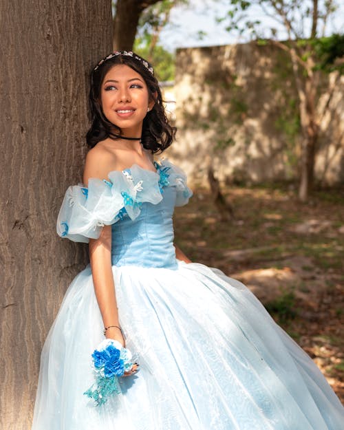 Young Woman in a Blue Gown with a Bouquet of flowers in her Hand