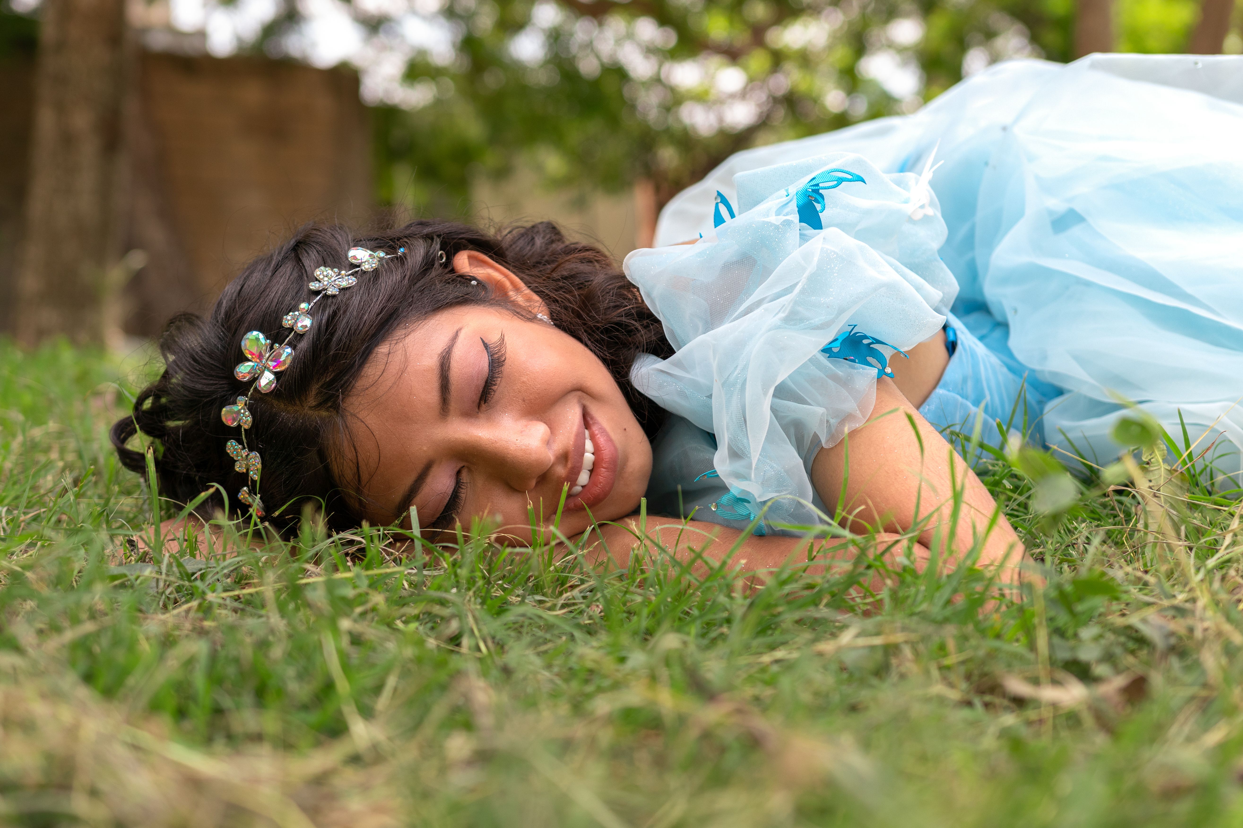 Brunette Woman in Blue Dress Lying Down on Grass · Free Stock Photo