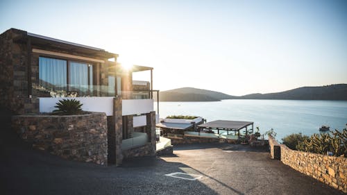 Free Sun Piercing of Brown Concrete House Near Sea Stock Photo