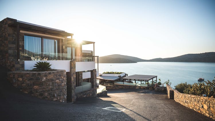 Sun Piercing Of Brown Concrete House Near Sea