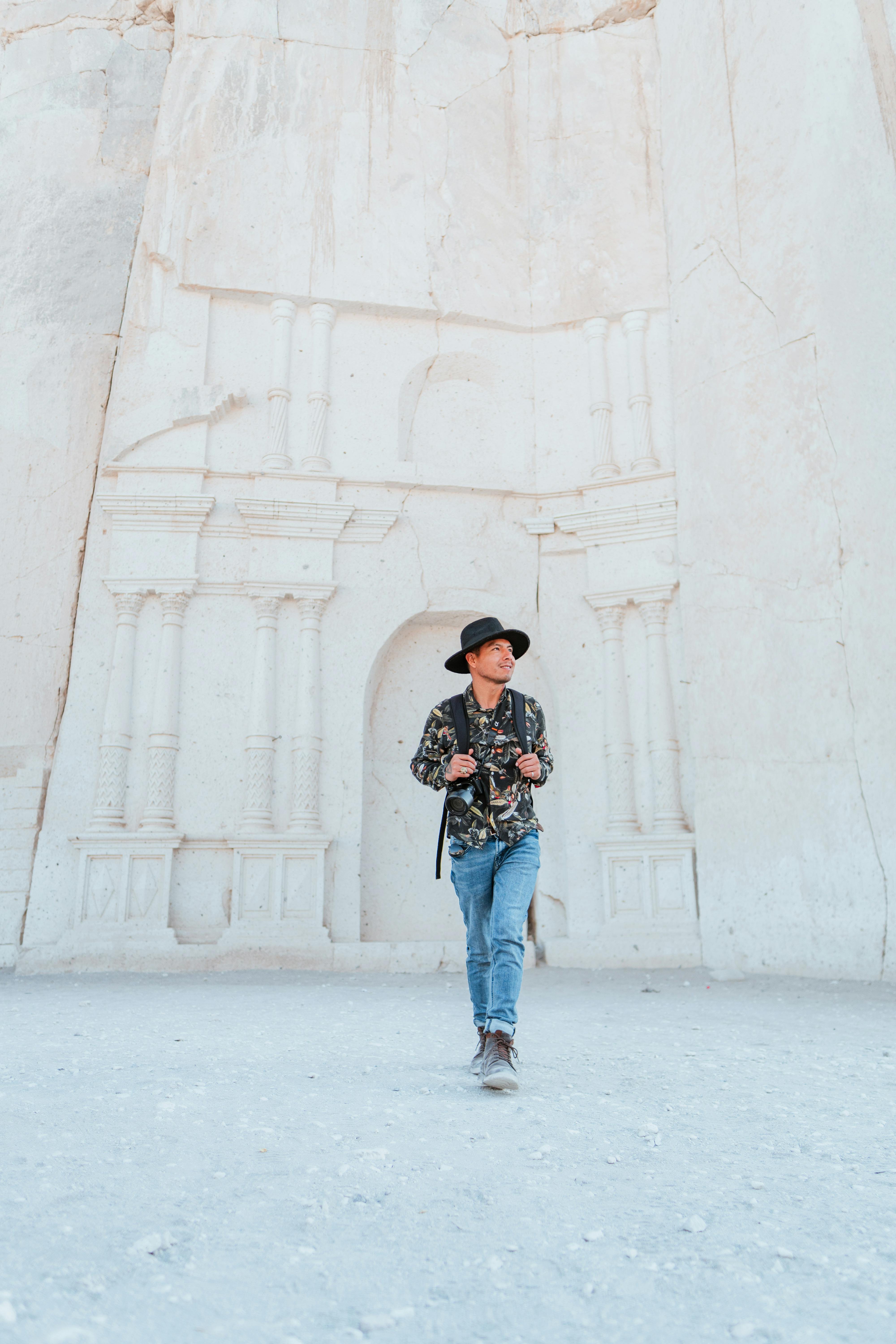 A man walks in front of ancient white stone architecture in Arequipa, Peru, capturing its historic allure.