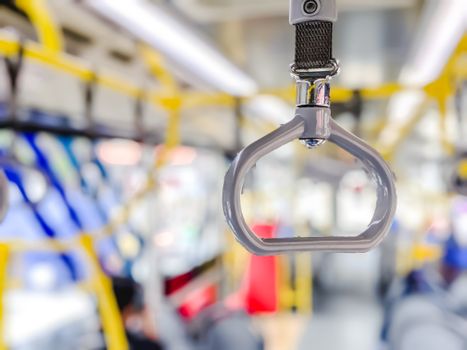 Isolated focus of hand holder inside public buses transportation highly required for providing safety and comfying passengers during the trip. Blurred background 