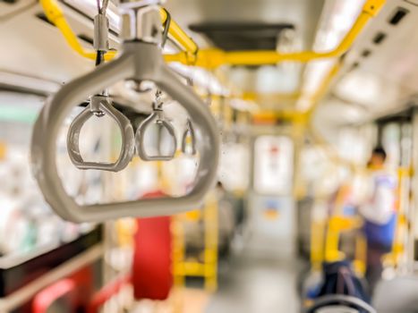 Blurred foreground and isolated focus of hand holder inside public buses transportation highly required for providing safety and comfying passengers during the trip.