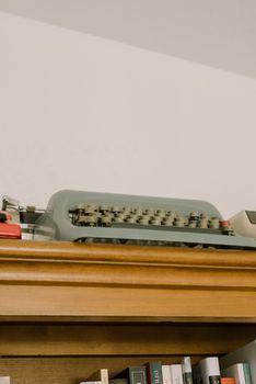 A classic typewriter displayed on a wooden shelf, capturing a nostalgic vintage atmosphere.