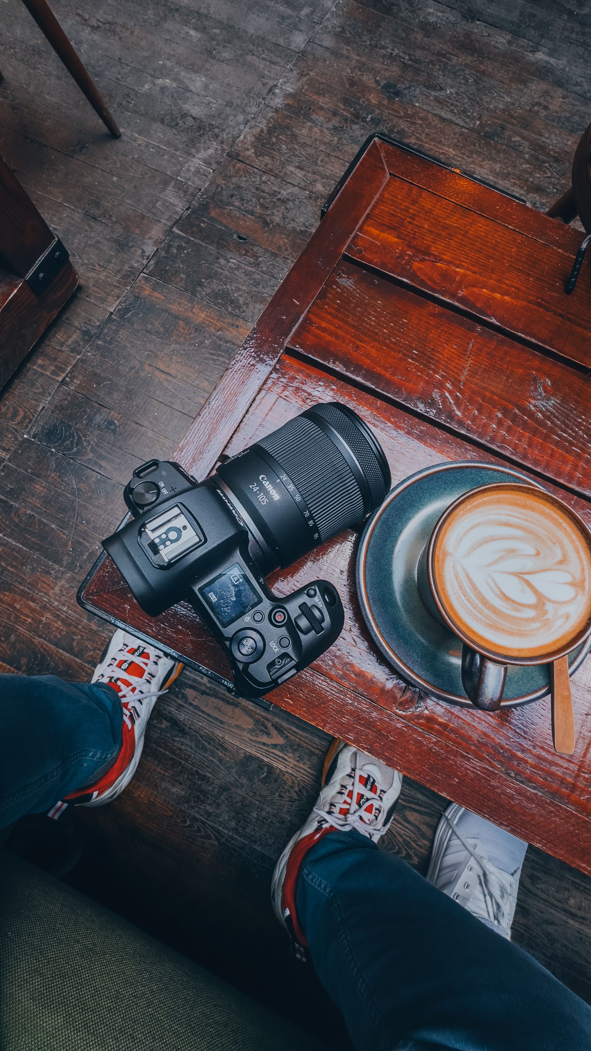 An SLR Camera and a Cup of Coffee on the Table · Free Stock Photo