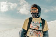 一个穿戴冬装和护目镜的人站在雪地里，准备迎接冒险