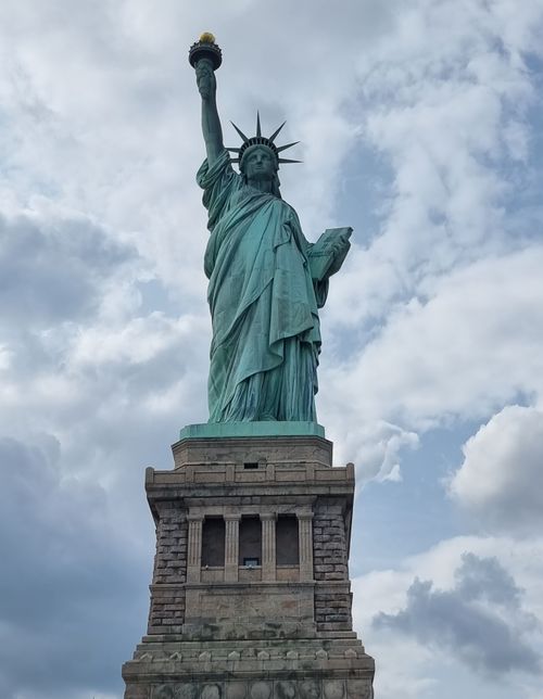 Free Breathtaking view of the Statue of Liberty in New York City under a cloudy sky. Stock Photo