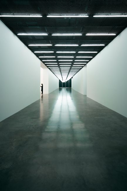 Sleek minimalist design inside a London art gallery with dramatic lighting and empty hallways.