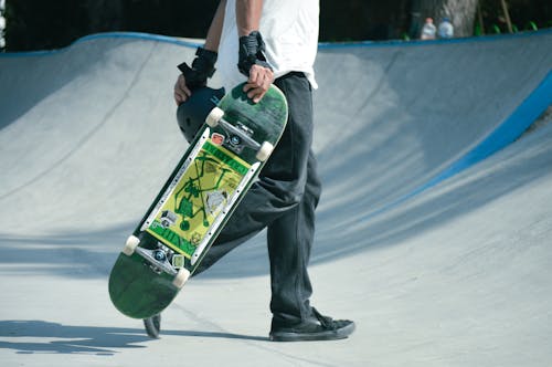 Man Walking with Skateboard in Skatepark