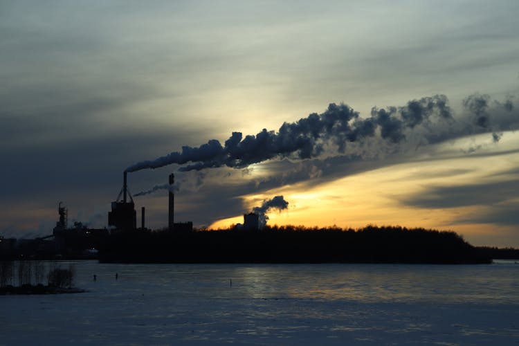 Smoke From Chimneys On Coast At Sunset In Winter