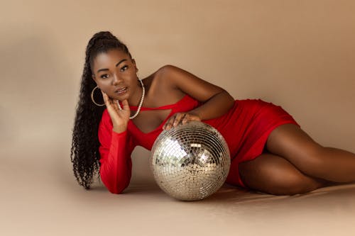 Woman in Red Dress Lying Down with Disco Ball