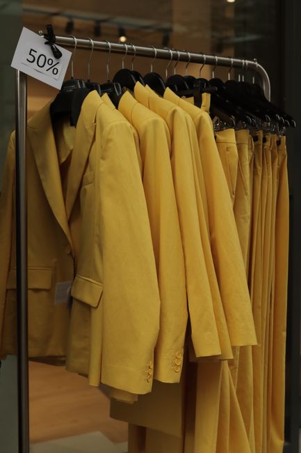 A rack of yellow blazers on sale with a 50% discount in a Jönköping, Sweden boutique.