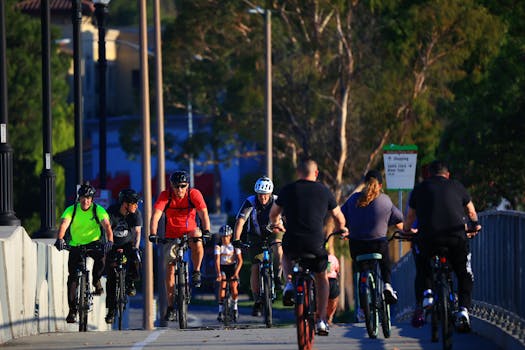 A group of cyclists riding on an urban bridge during the daytime, engaging in recreational activity.