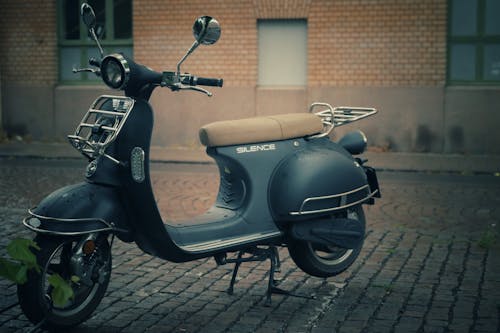 Motor Scooter Parked on Pavement