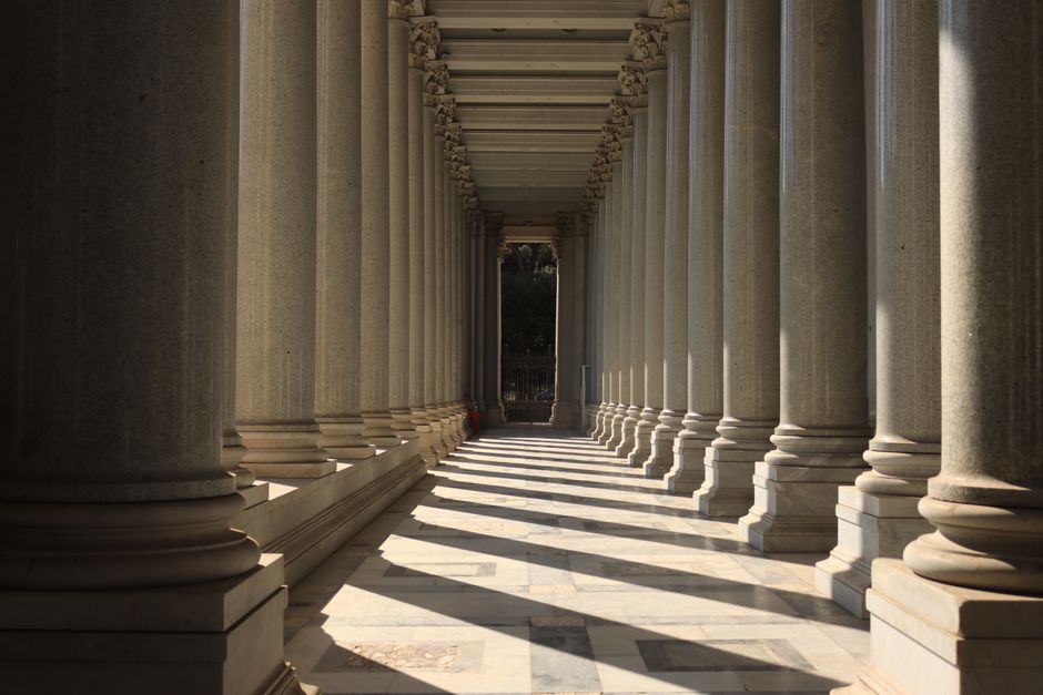Columnata elegante con luz y sombras en Roma, Italia, destacando la belleza arquitectónica antigua.