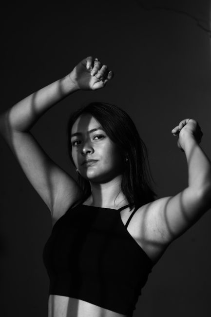 Artistic black and white portrait of a woman with shadows casting on her face, set in Oaxaca, Mexico.