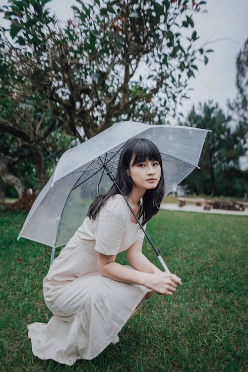 Woman Squatting with Transparent Umbrella