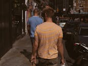 在一条繁忙的城市街道上，两名男子在车里行走，展现了城市生活的景象