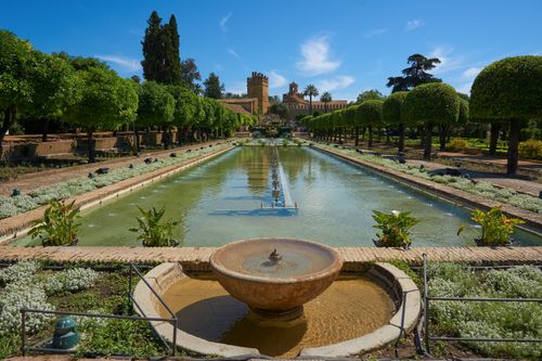 Free Explore the tranquil gardens of Alcázar de los Reyes Cristianos in Córdoba, Spain, with its historic architecture and lush greenery. Stock Photo