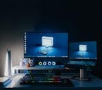 A desk with two computer monitors and a keyboard