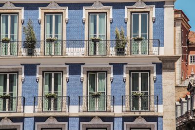Lisbon building facade with blue azulejo tiles and balconies, photo by Pascal B. on Pexels