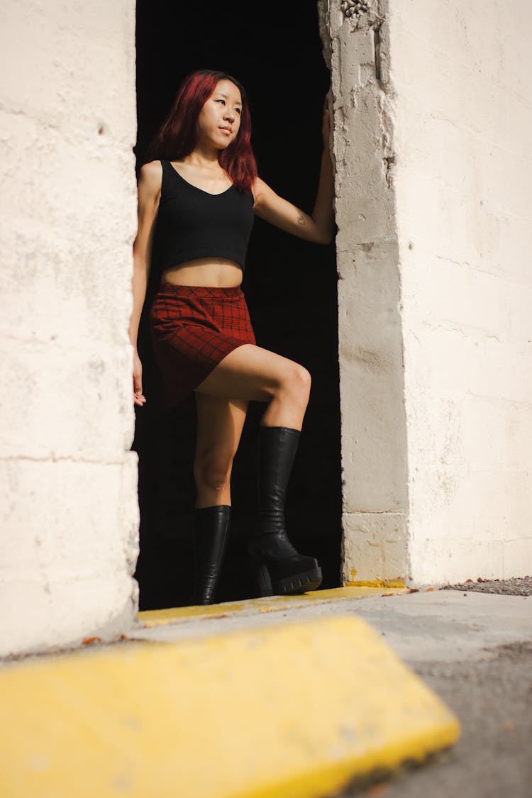 Redhead Woman Wearing Red Shorts, Standing In A Doorway