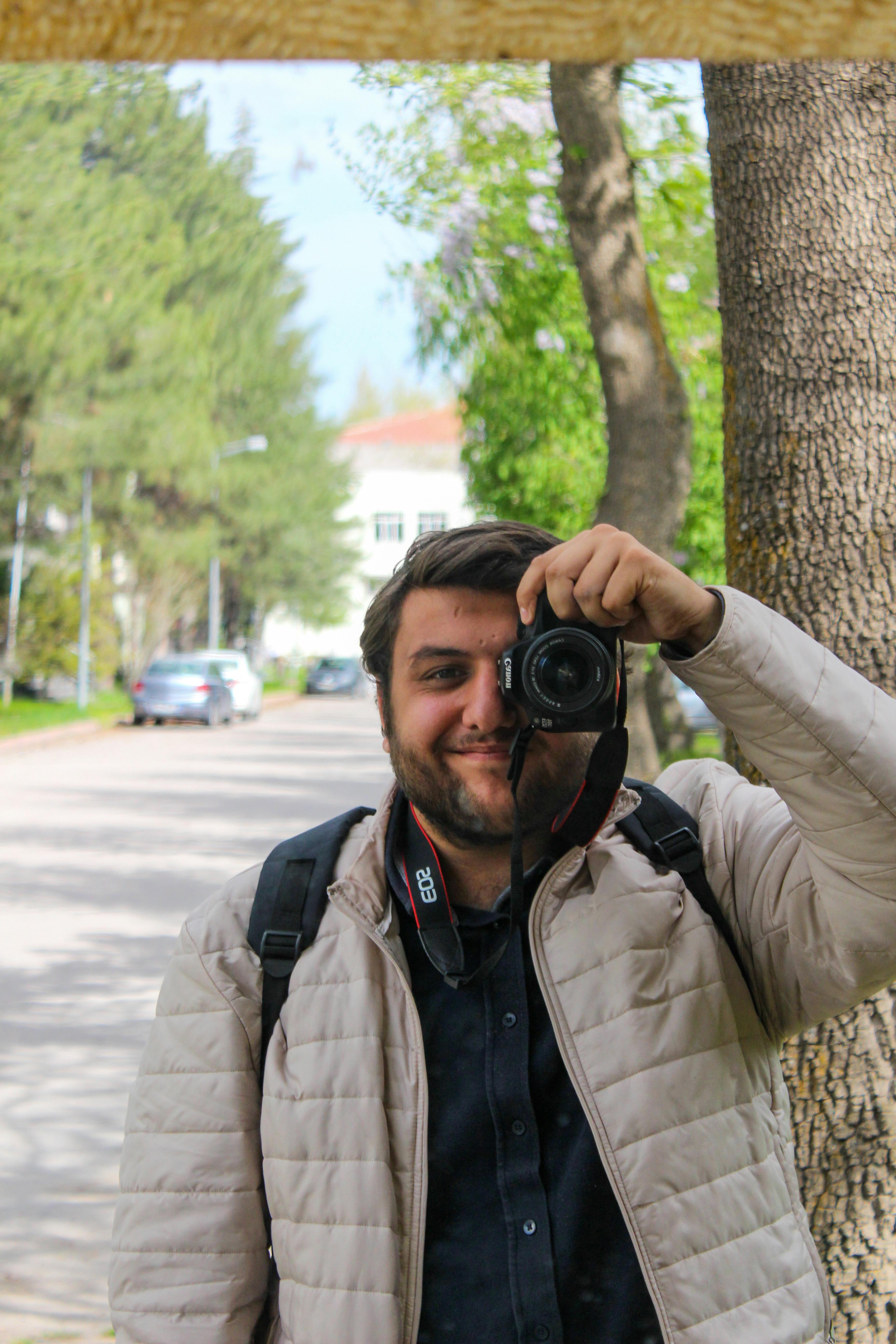 A photographer takes a selfie while capturing urban street moments. Ideal for creative and urban themes.
