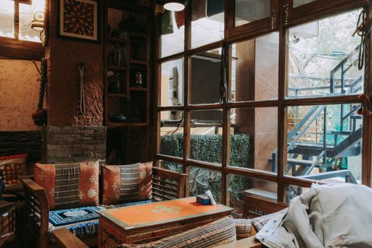 Charming vintage-style room with colorful cushions and rustic wooden furniture.