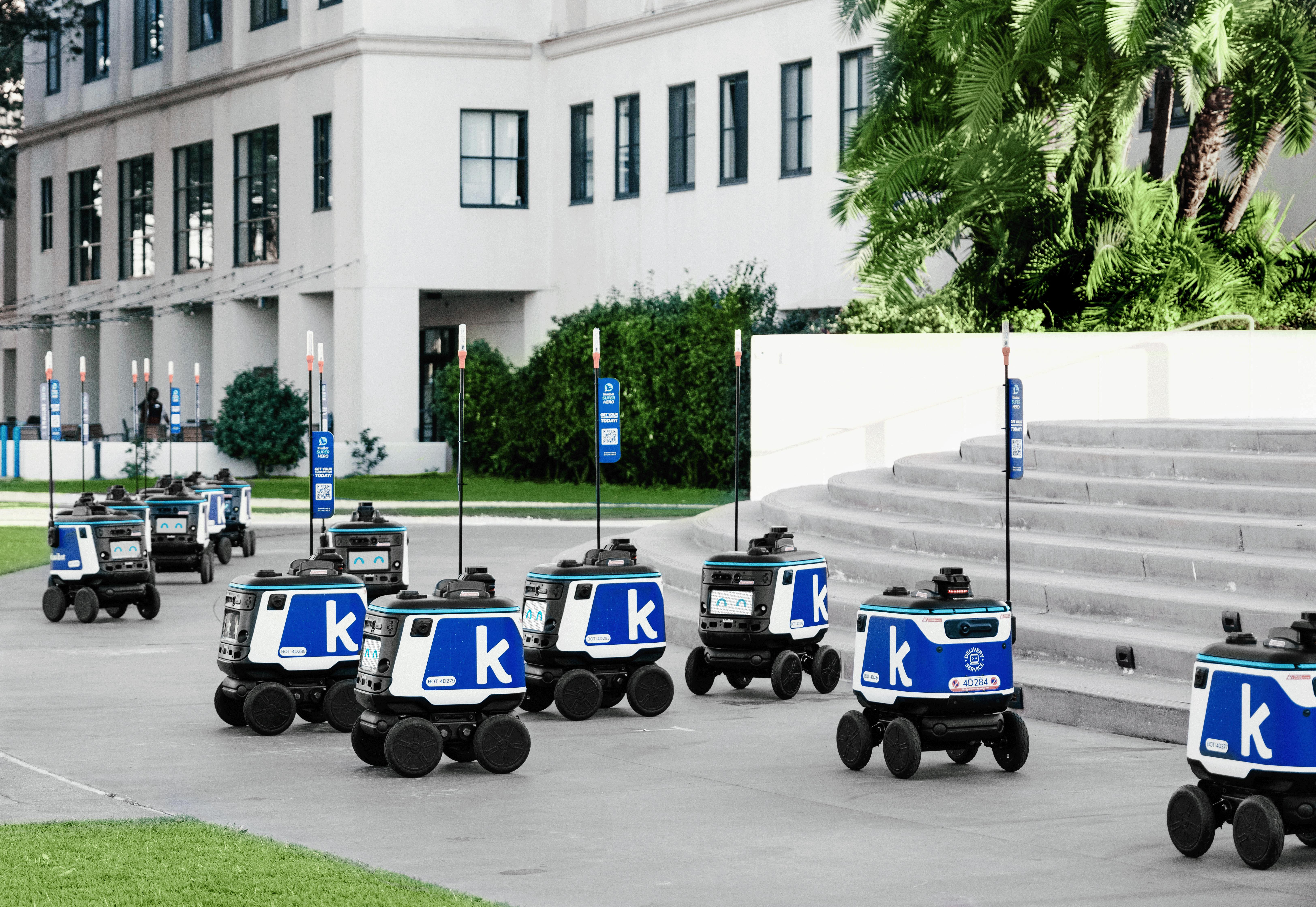 Futuristic autonomous robots delivering packages in an urban setting, showcasing modern technology.