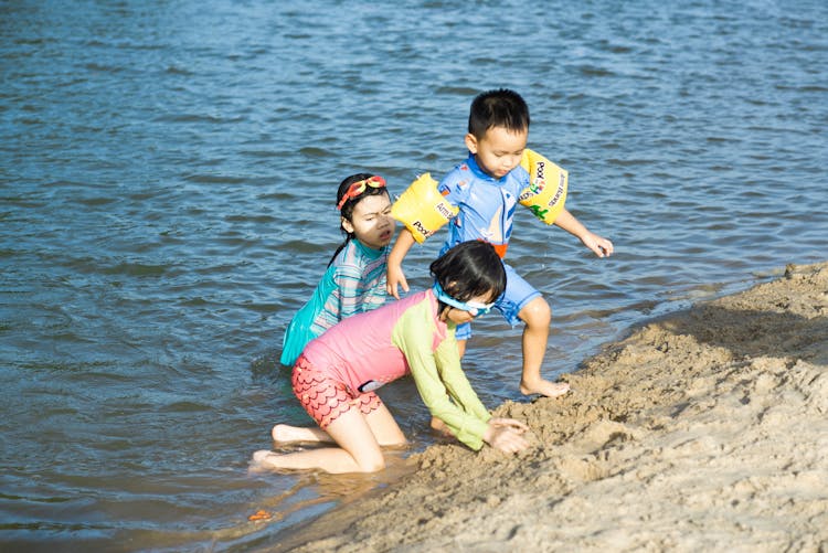 Boy And Girls Playing On Lakeshore