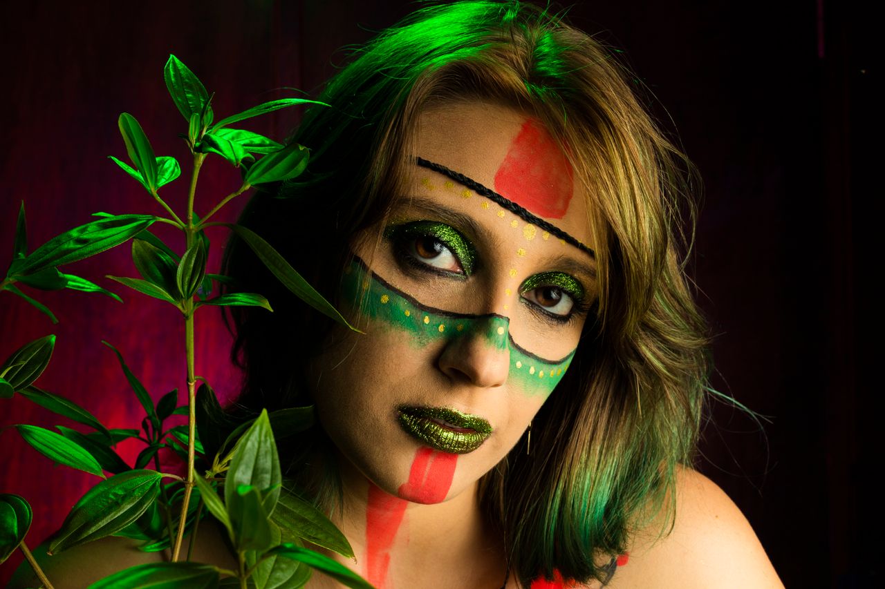 artistic portrait of a woman with tribal face paint and vibrant colors