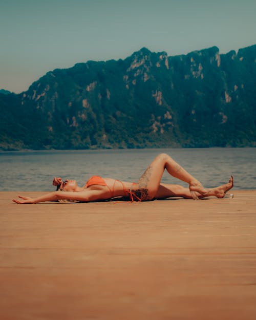 Free Woman in Bikini Lying Down on Beach Stock Photo