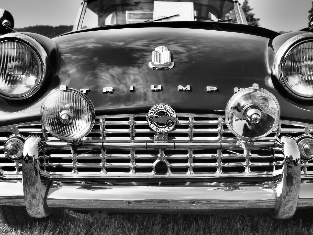 close up front view of a vintage triumph tr3 car captured in black and