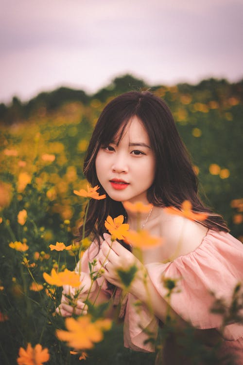 Pretty Young Woman in a Field of Flowers