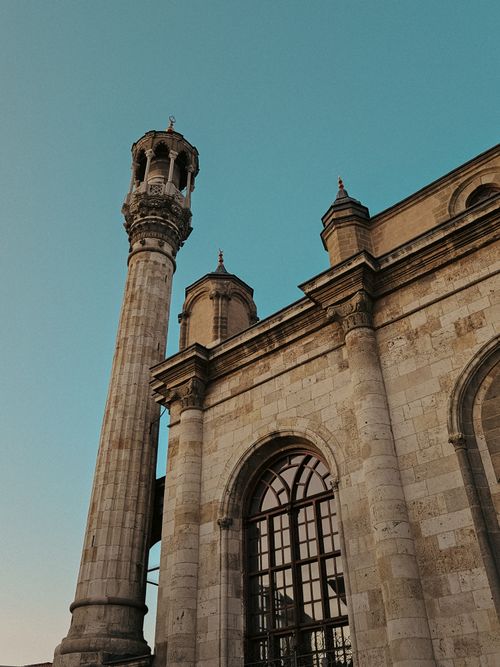 Free Stunning view of an Ottoman-style mosque facade with a minaret under a clear blue sky in Konya, Turkey. Stock Photo
