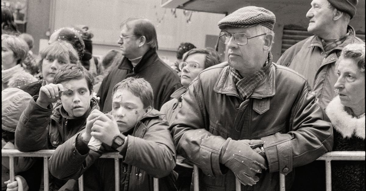 a person standing on a soapbox in a stock exchange, crowd watching