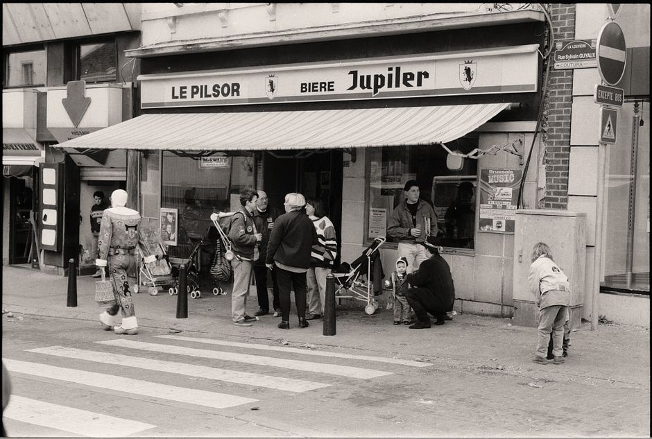 Black and white photo of people gathered outside a café in Belgium.