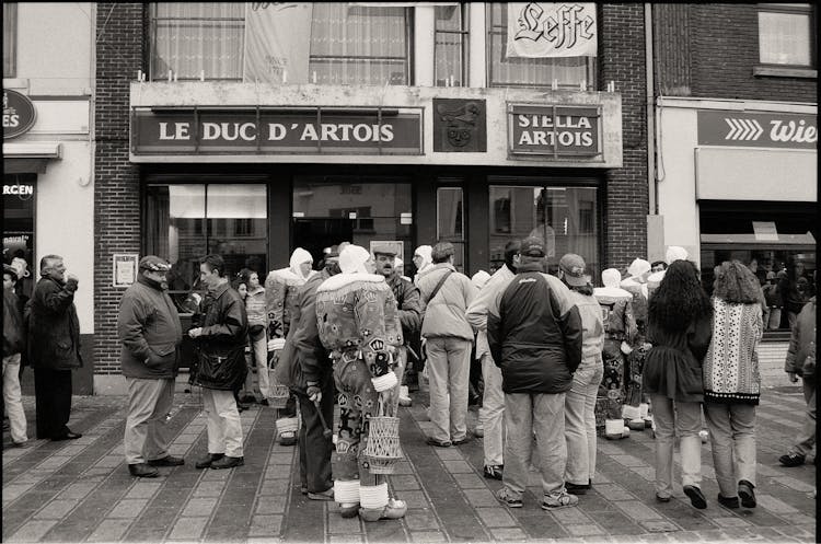 Group Of People Standing In Queue In Black And White