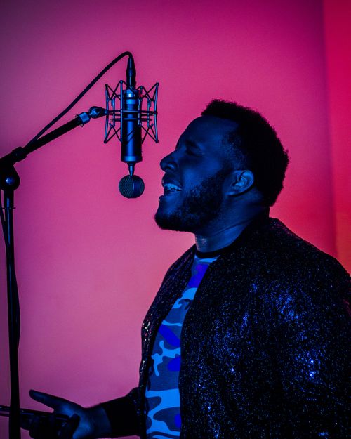 Free A dynamic portrait of a singer with closed eyes performing passionately in a recording studio. Stock Photo