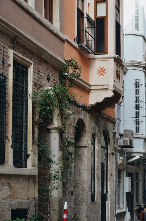 Free A beautiful view of ivy-covered historic buildings with arches in an urban setting. Stock Photo