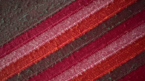 fabric warp weft handmade handwoven handcrafted handicraft hand loom cotton brown red pink orange green closeup pattern lines channel colorful dyed