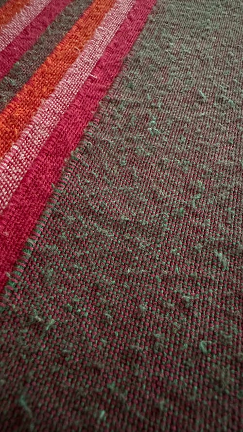 fabric warp weft handmade handwoven handcrafted handicraft hand loom cotton brown red pink orange green closeup pattern lines channel colorful dyed
