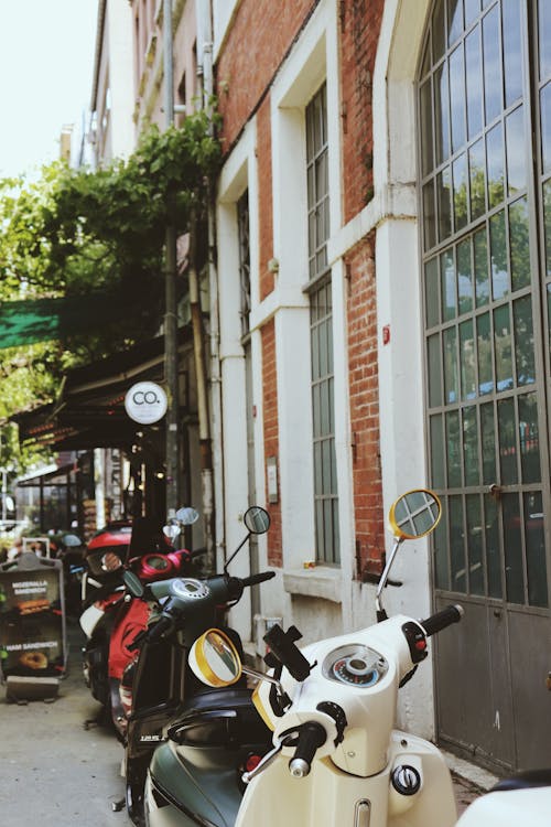 Motor Scooters Parked near Building Walls