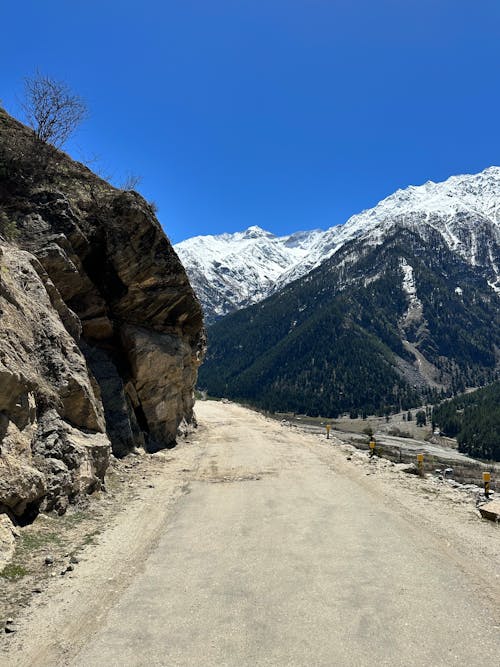 View of a Trail in Snowcapped Mountains under Blue Sky 