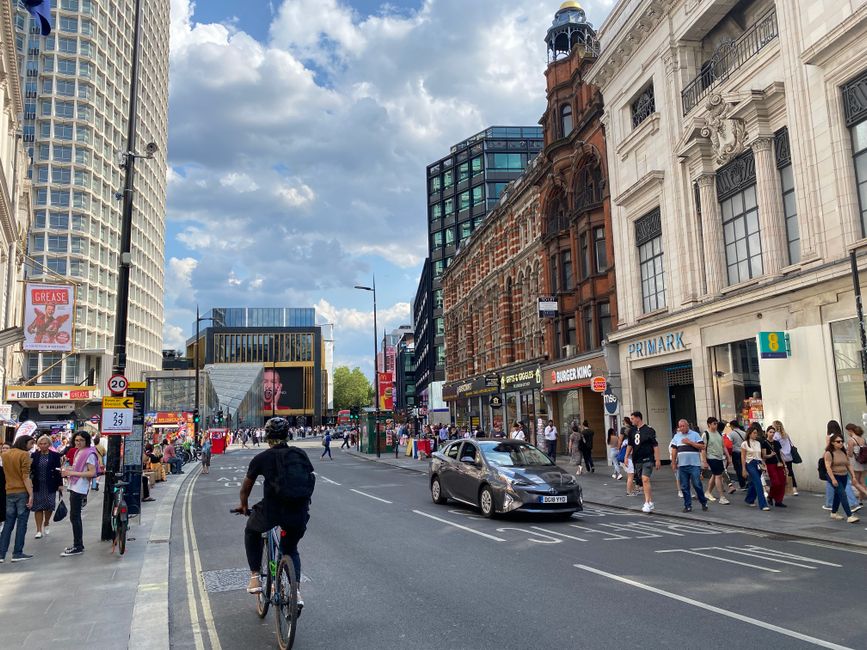 A bustling day in London's city center with cyclists and pedestrians on a busy street.