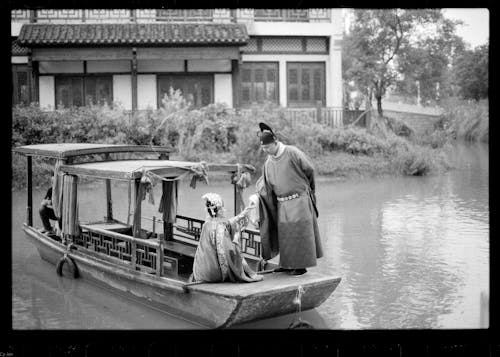 Couple Wearing Traditional Outfits on a Boat in Black and White