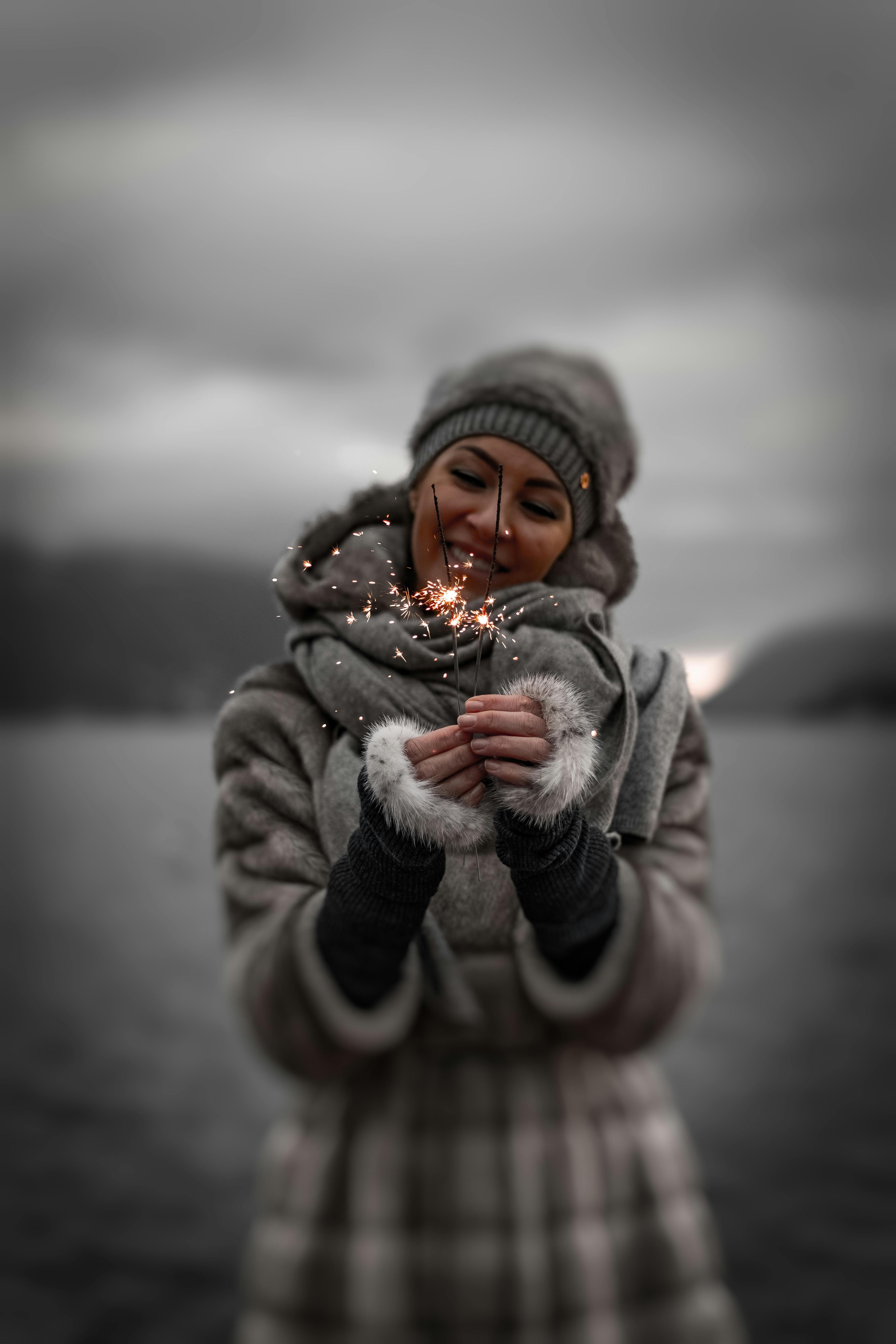 Photo of Smiling Woman Holding Lit Sparklers